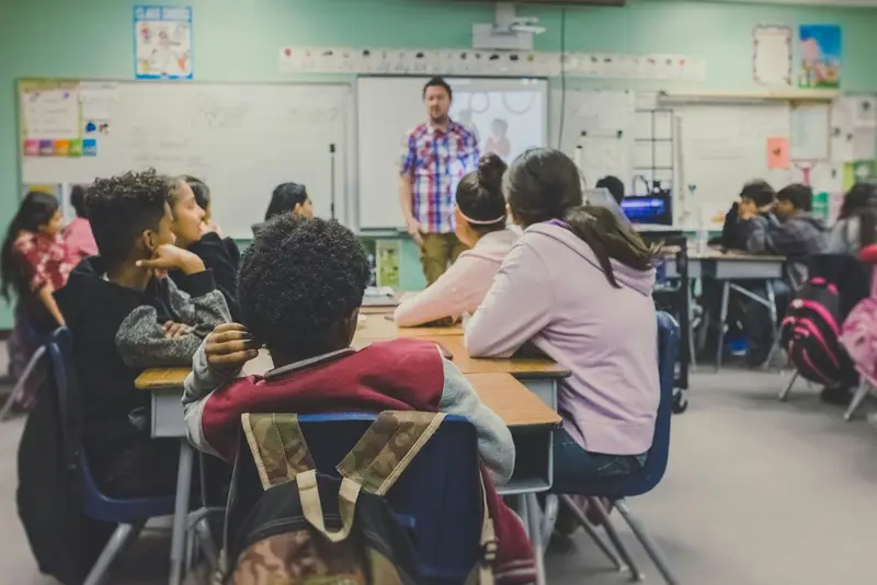 Pupils listening to their teacher during a lesson in a decorated classroom