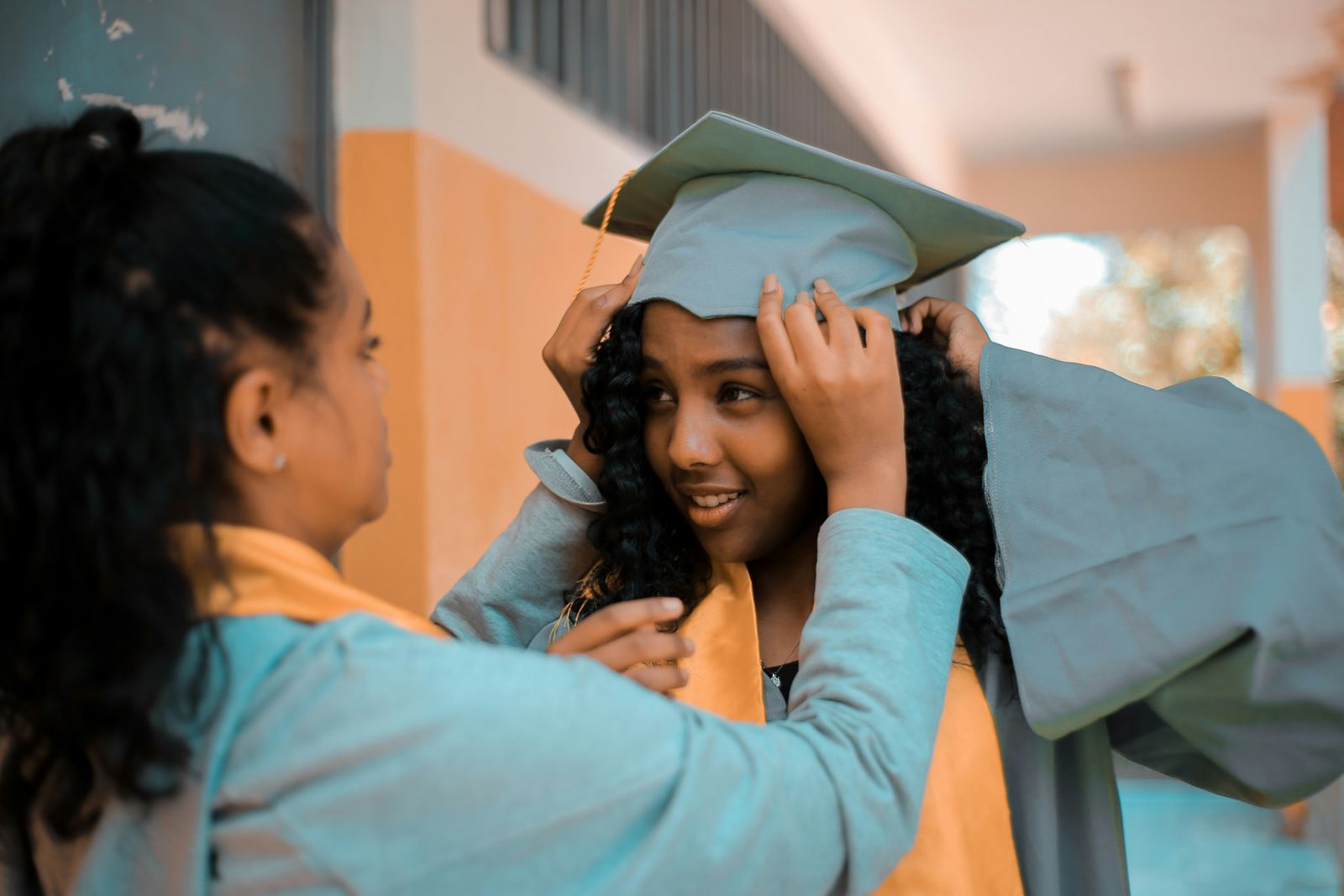 A mother adjusting her daughter's graduation cap before the ceremony