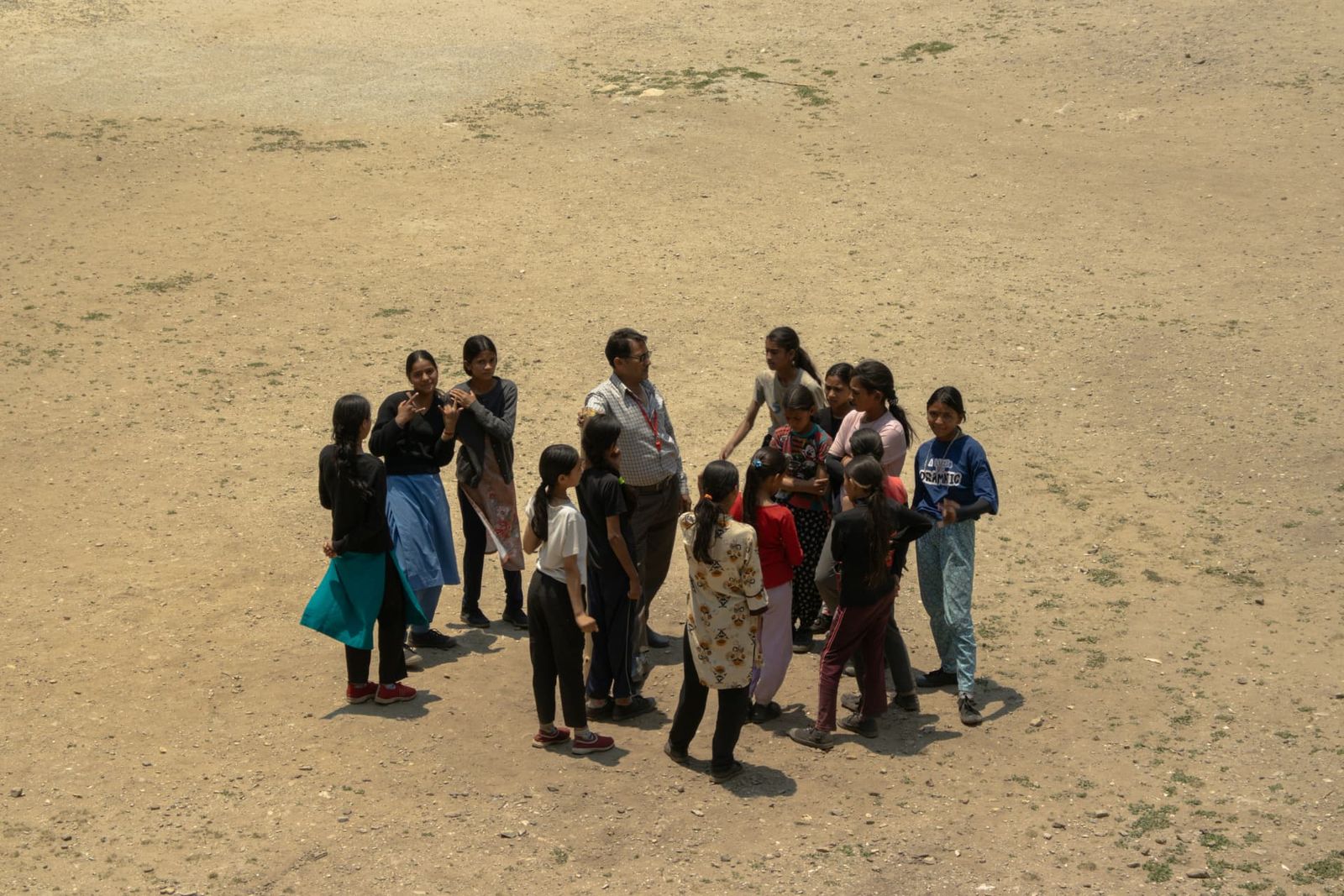 A community worker meeting a group of girls on an open field